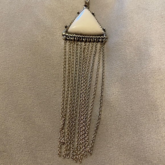 Necklace with white and silver colored medallion.